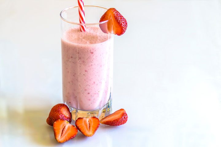 strawberry banana smoothie with fresh strawberries on side.