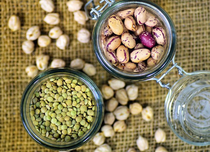 overhead of jars of legumes like lentils and beans as excellent vegetarian protein source.