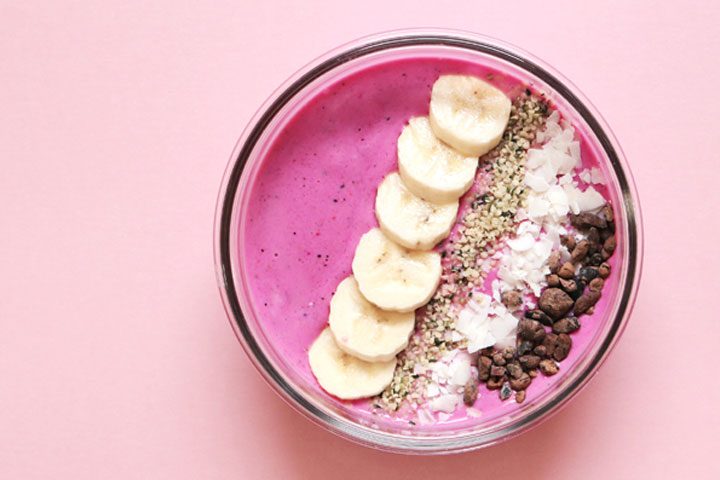 top view of simple easy smoothie bowl with banana, seeds, coconut flake toppings.