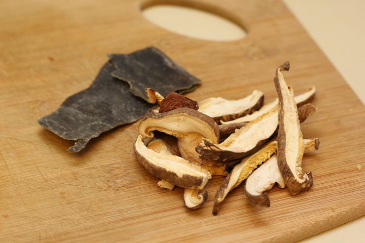 vegan tonkotsu ramen ingredients konbu and dried mushroom on cutting board.