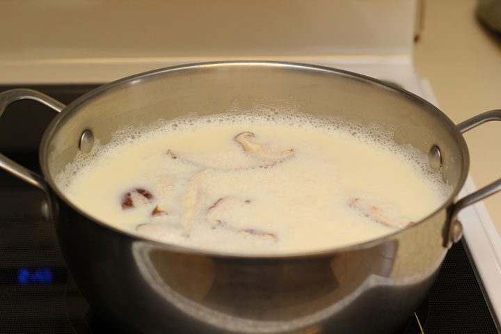 vegan tonkotsu boiling soy milk ramen on stove with mushroom.